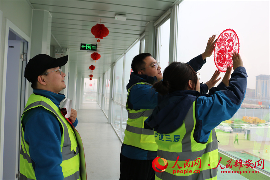 建設(shè)者們正在貼窗花。中建三局集團(tuán)北京有限公司供圖