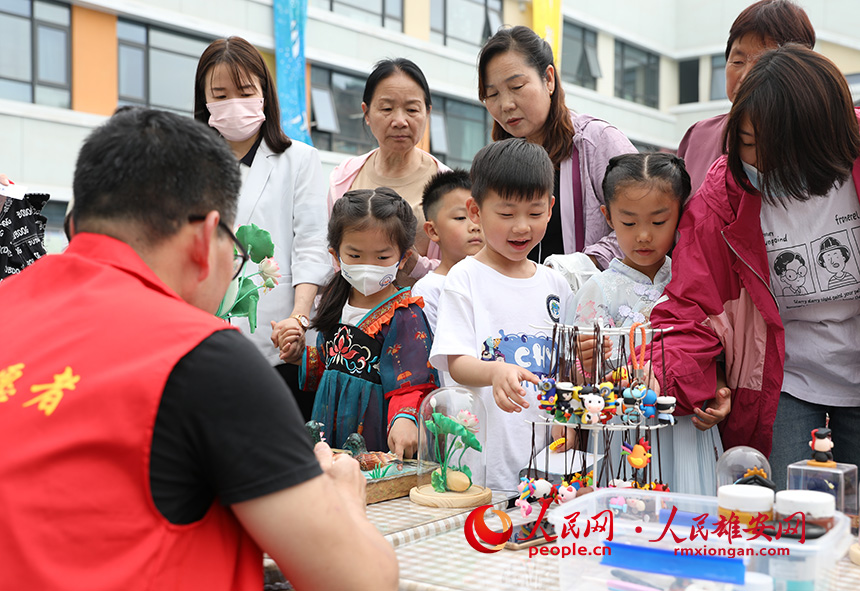 5月31日，雄安容和樂安幼兒園舉辦傳統(tǒng)文化游園活動。活動邀請了雄安當(dāng)?shù)胤沁z文化傳承人走進幼兒園，與孩子和家長交流互動。通過現(xiàn)場接觸非遺項目，讓孩子們零距離認(rèn)識非遺、熟悉非遺，感受非遺之美。人民網(wǎng) 李兆民攝