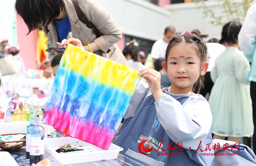 5月31日，雄安容和樂安幼兒園舉辦傳統(tǒng)文化游園活動?；顒友埩诵郯伯?dāng)?shù)胤沁z文化傳承人走進(jìn)幼兒園，與孩子和家長交流互動。通過現(xiàn)場接觸非遺項目，讓孩子們零距離認(rèn)識非遺、熟悉非遺，感受非遺之美。人民網(wǎng) 李兆民攝