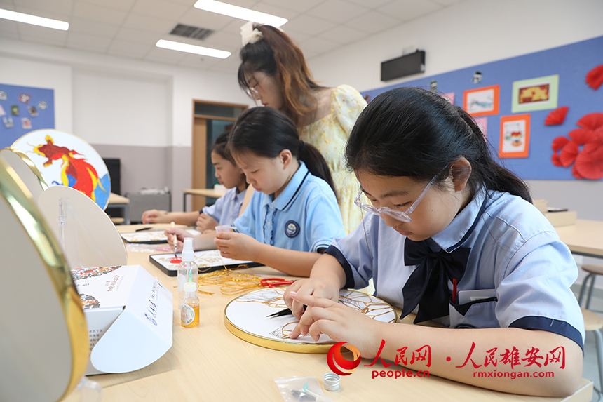 暑假期間，雄安容和樂民小學(xué)老師指導(dǎo)學(xué)生制作中國傳統(tǒng)工藝品——掐絲琺瑯畫，體驗非遺藝術(shù)的制作流程。人民網(wǎng) 李兆民攝 (2)